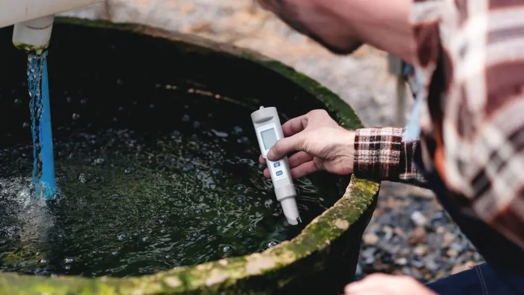Inspector-using-a-device-to-test-the-quality-of-well-water-on-a-farm